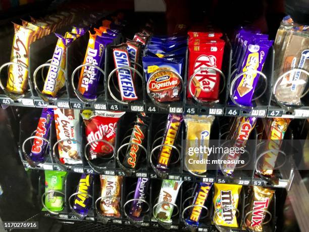 Manchester, Greater Manchester, England, UK - June, 16 2019: Image of chocolate bars, cakes and biscuits in a snack vending machine.