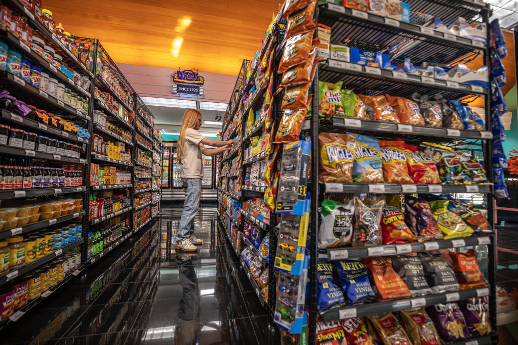 The Sweet Spot bodega quietly opened two weeks ago on the corner of 4th and B Street to offer a convenience store option in the heart of downtown Santa Rosa Wednesday December 4, 2024. Store Manager Branden Carrell stocks snacks at the downtown Santa Rosa store. (Chad Surmick / The Press Democrat)